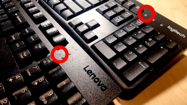 Press the caps lock key on the Lenovo keyboard. Both Lenovo and Logitech keyboards light their caps lock LED.